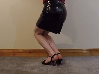 Male strutting in block heel sandals and shiny P.V.C skirt
