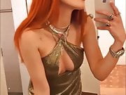 Bella Thorne with red hair and showing cleavage in a dress