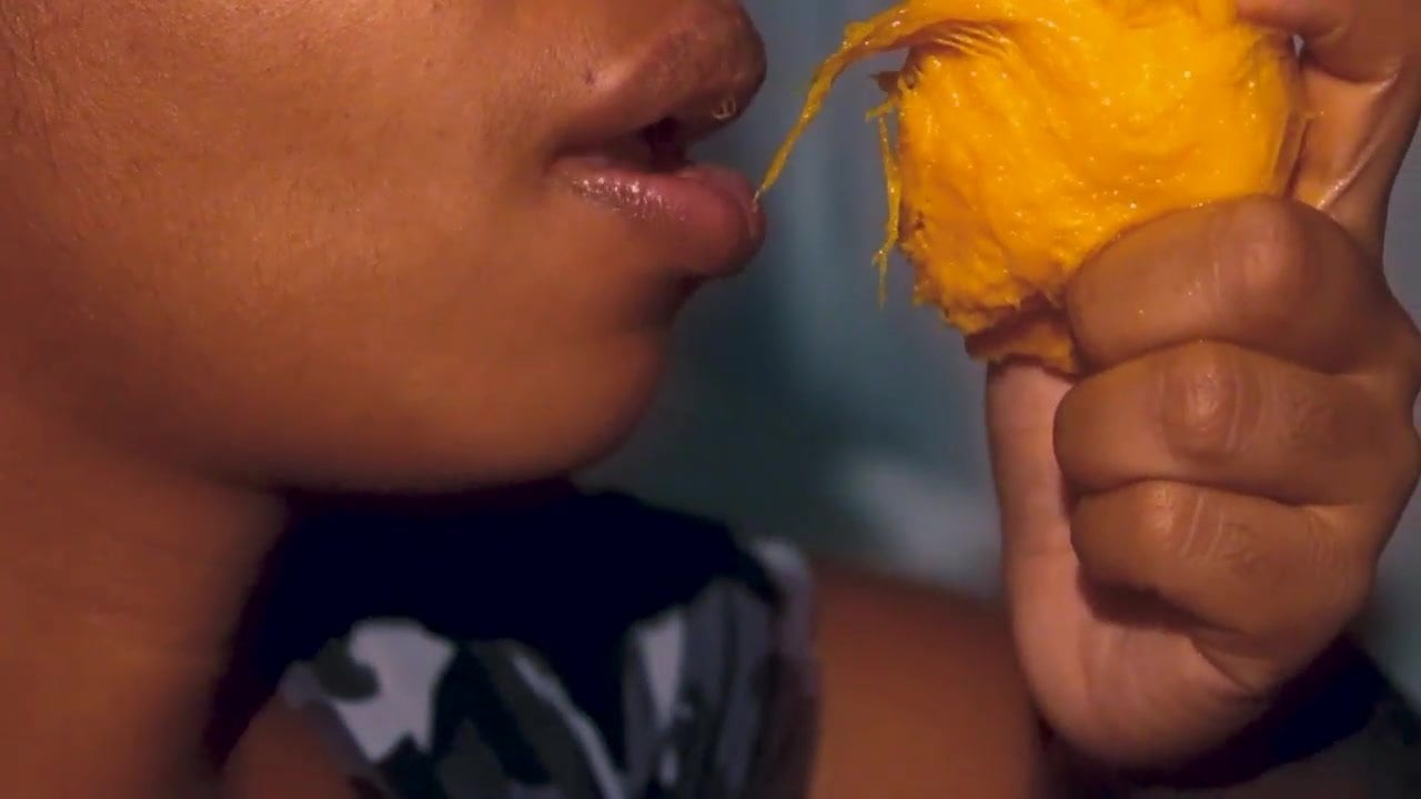 Sexy mouth ebony playing with a mango